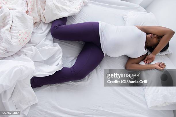 uncomfortable black pregnant woman sleeping in bed - prenatal care ストックフォトと画像
