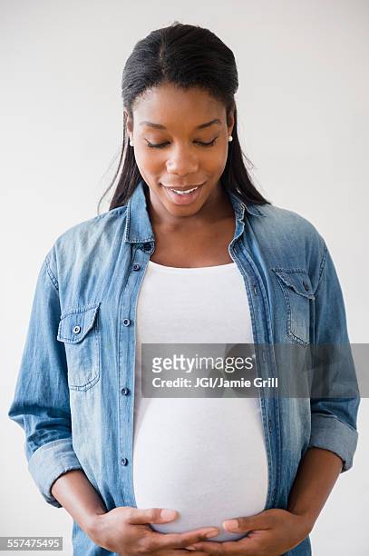 black pregnant woman admiring her stomach - prenatal care ストックフォトと画像