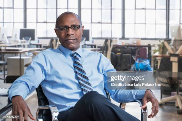 black businessman smiling in empty office - african american businessman stock pictures, royalty-free photos & images