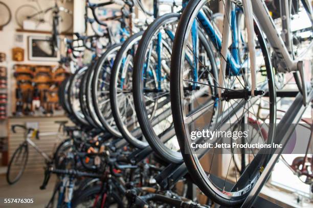 bicycles hanging on rack in store - buying a bike bildbanksfoton och bilder