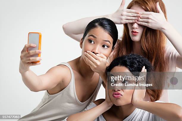 women posing and taking cell phone selfie - taking selfie white background stockfoto's en -beelden