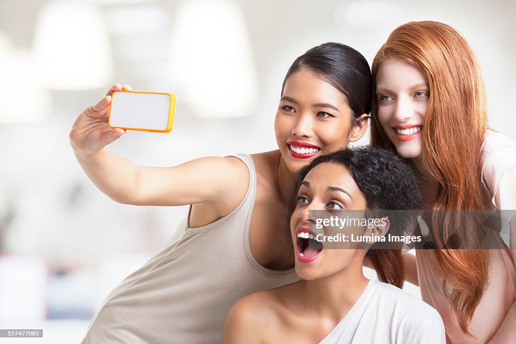 Smiling women taking cell phone selfie