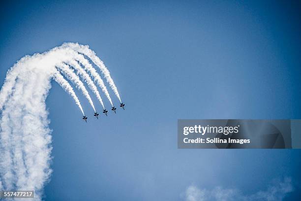 jets flying in formation in cloudy blue sky - avion de chasse photos et images de collection