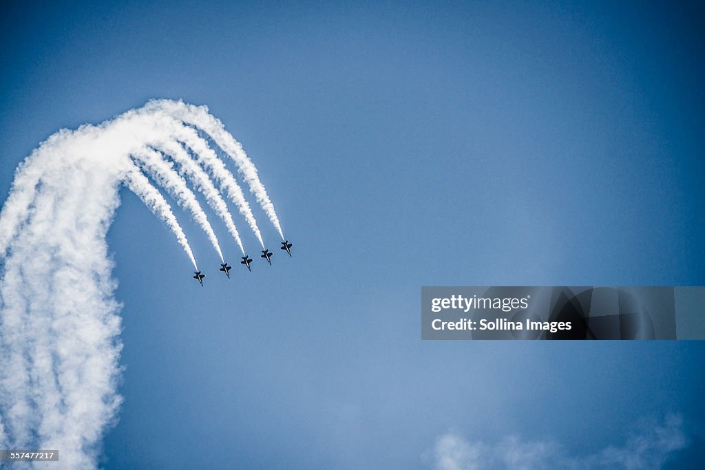 Jets flying in formation in cloudy blue sky