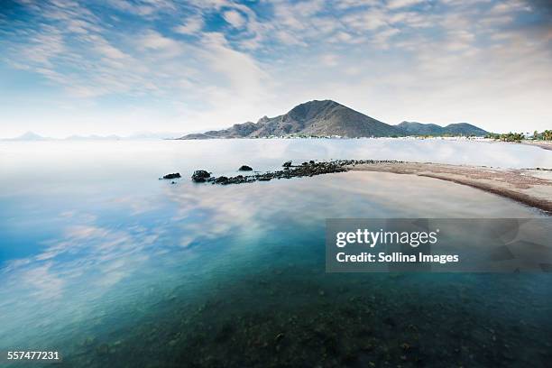 cloudy blue sky reflecting in lake - guaymas stock-fotos und bilder