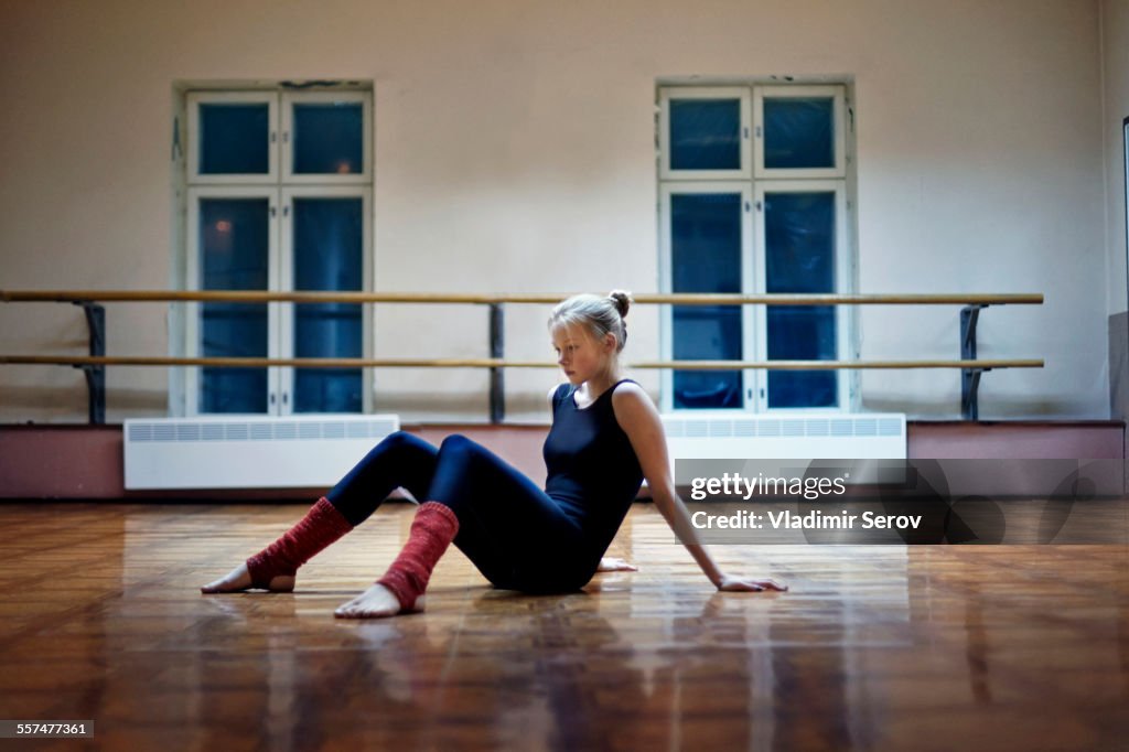 Caucasian dancer sitting on studio floor