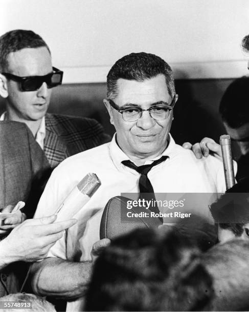 American professional football coach Vince Lombardi holds a football and participates in a press conference, late 1950s. Lombardi served as offensive...