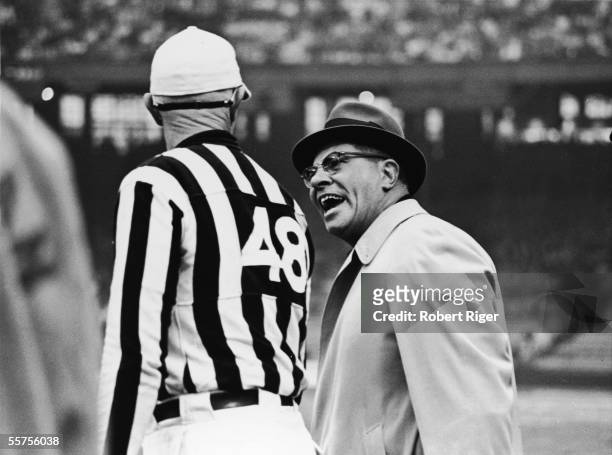 American professional football coach Vince Lombardi appears irritated while he confers with a referee during a game, late 1950s to early 1960s....