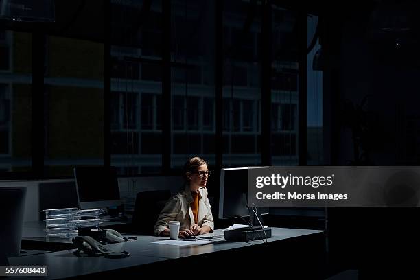 businesswoman using computer in dark office - övertid bildbanksfoton och bilder