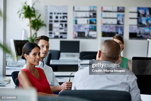 confident businesswoman with colleagues in meeting - red office chair stock pictures, royalty-free photos & images