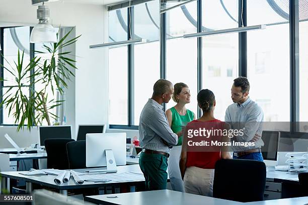 confident professionals discussing in office - red shirt stock pictures, royalty-free photos & images