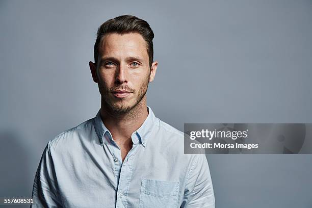 portrait of confident young businessman - man standing against grey background foto e immagini stock