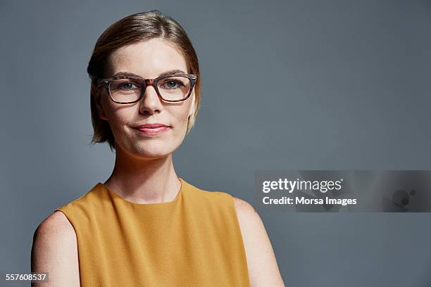 smiling businesswoman over gray background - businesswoman classy stockfoto's en -beelden