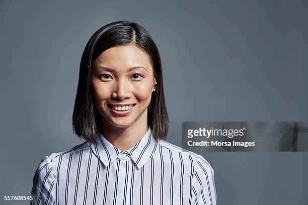 smiling businesswoman over gray background - striped shirt stockfoto's en -beelden