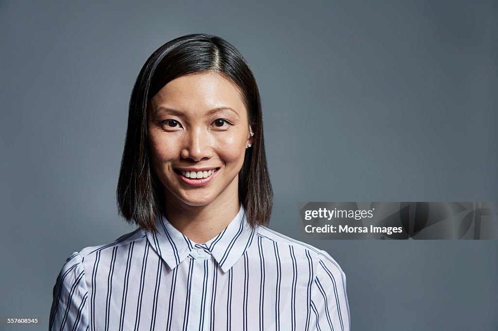 Smiling businesswoman over gray background
