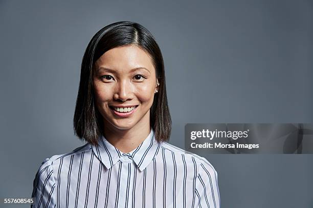 smiling businesswoman over gray background - headshot photos stock pictures, royalty-free photos & images