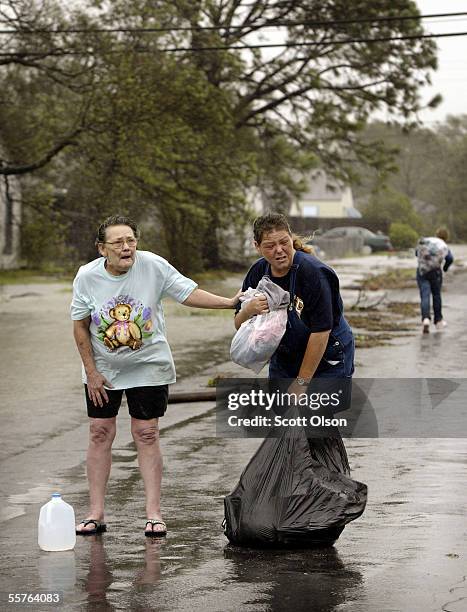 Kandy Huffman helps her mother-in-law Judith Broussard navigate flooded streets as they try to make their way to Huffman's home following Hurricane...