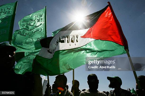 Mourners wave Palestinian and Hamas flags while they wait the funeral of 15 Palestinian bomb victims in the Al-shuhada cemetery, September 24, 2005...