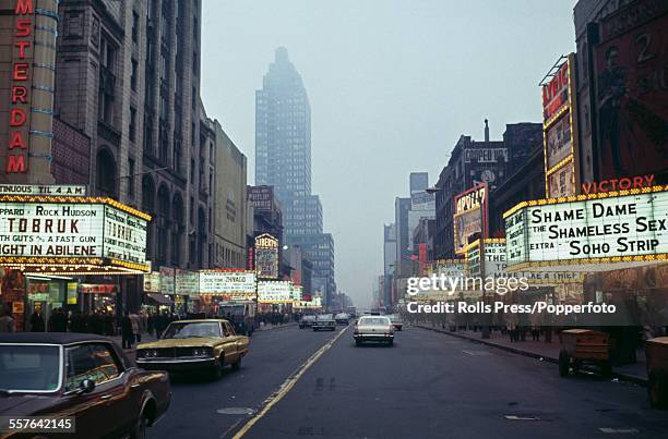 View of 42nd street at Times Square with marquees above cinemas advertising both Hollywood and pornographic films on presentation in New York in...