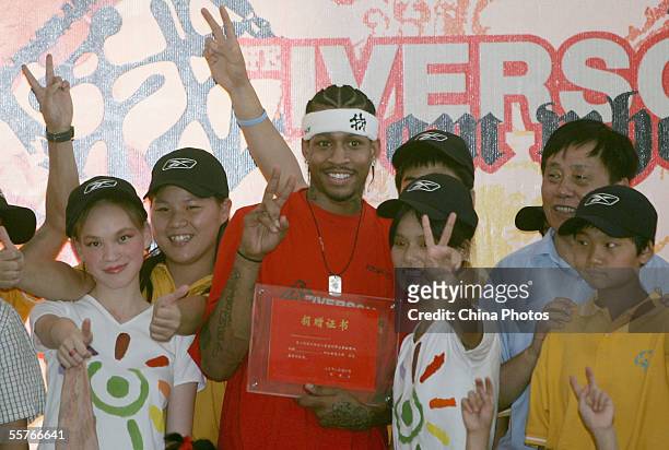 Player, Philadelphia 76ers guard Allen Iverson poses for pictures with orphans and a donation certificate at Shanghai Children's Welfare Center on...