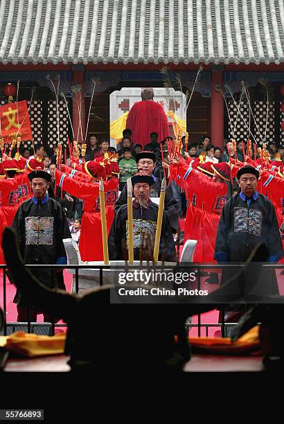 Confucian scholars dressed in ancient clothes pay respects to Confucius , during a ceremony to worship the Chinese philosopher and educator at the...