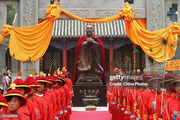 Students dressed in ancient clothes stand in front of the statue of Confucius , during a ceremony to worship the Chinese philosopher and educator at...