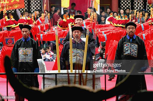 Confucian scholars dressed in ancient clothes pay respects to Confucius , during a ceremony to worship the Chinese philosopher and educator at the...