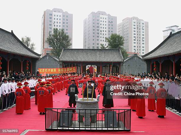 Confucian scholars and students dressed in ancient clothes pay respects to Confucius , during a ceremony to worship the Chinese philosopher and...