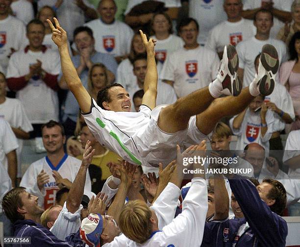 Players and members of Slovakia's Davis cup team throw Dominik Hrbaty in the air after he won over Argentina's Guillermo Coria during the third day...