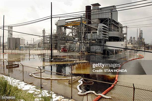 An oil spill in flood waters is contained by plastic tubes at the idle Valero oil refinery 25 September 2005 in Port Arthur, Texas in the aftermath...