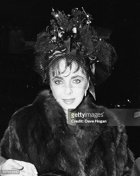 Actress Elizabeth Taylor wearing a fur coat with a ribbon and lace hat as she leaves Annabel's night club in London, February 19th 1988.