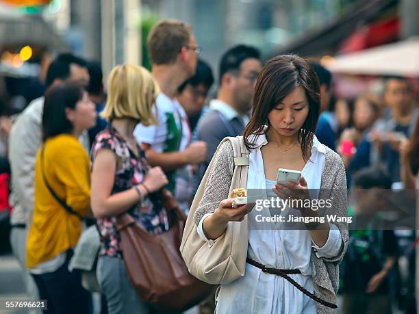 Tokyo, Japan Woman visiting Tsukiji Outer Market watching on her smart phone.