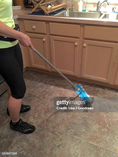 Woman Dry Mopping Kitchen Floor