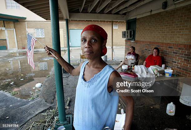 Debra Simmons plays with an American flag given to her by a National Guardsman outside the Melrose Motel where she rode out Hurricane Rita September...