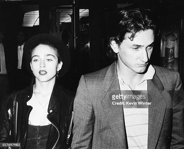 Singer Madonna and her husband, actor Sean Penn, walking along a street together, circa 1988.
