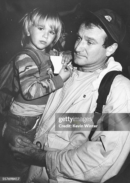 Comic actor Robin Williams holding his young son Zachary leaving Universal Amphitheatre after recording 'Comic Relief '87' in Los Angeles, November...