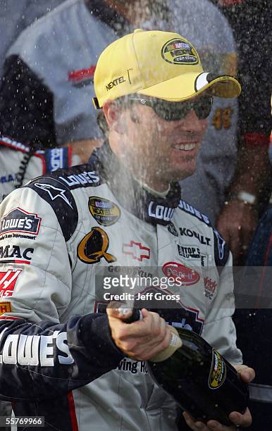 Jimmie Johnson, driver of the Lowe's Chevrolet, celebrates with a bottle of champagne after winning the NASCAR Nextel Cup Series MBNA NASCAR...