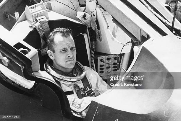 American astronaut Edward H White checking procedures in the spacecraft prior to escape training, for the Gemini 4 mission where he will be the first...
