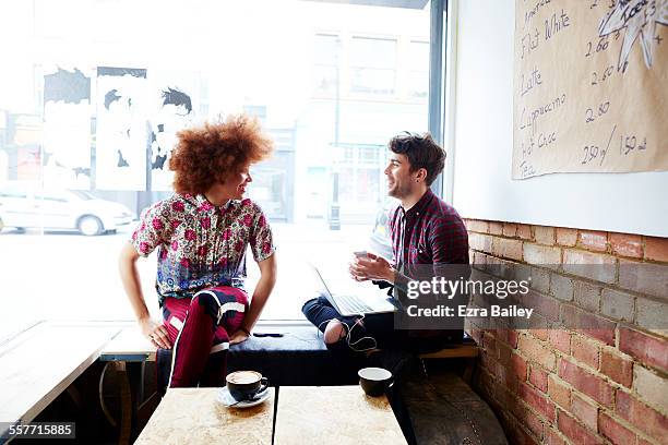 two friends chatting in coffee shop window - café homme vitre photos et images de collection