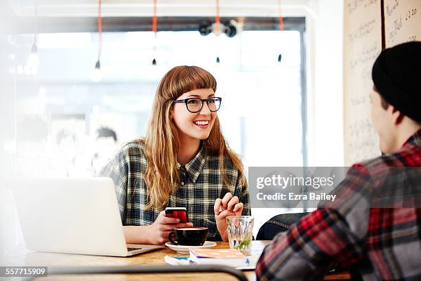 couple of friends chatting in coffee shop - fashionable glasses stock pictures, royalty-free photos & images