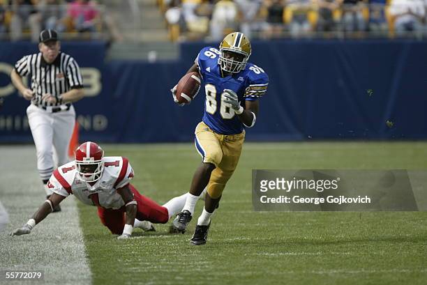 Wide receiver Greg Lee of the University of Pittsburgh Panthers runs away from defensive back Jason Perry of the Youngstown State Penguins after...