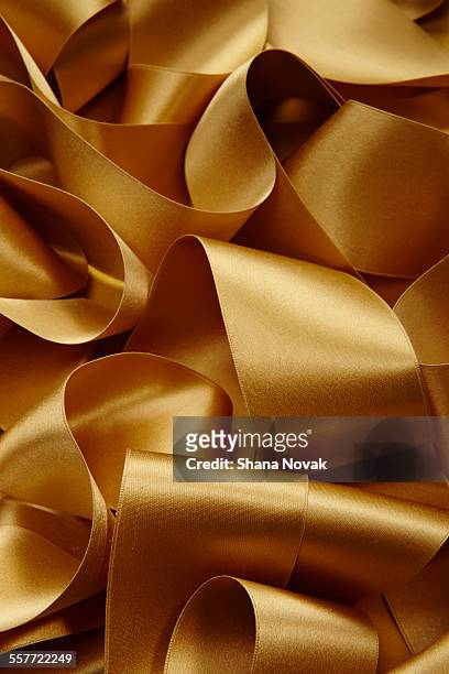 gold satin ribbon - shiny fabric stock pictures, royalty-free photos & images