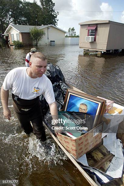 Lance Hargrave helps rescue belongings from the home of his wife's grandparents which was flooded by Hurricane Rita September 26, 2005 in Abbeville,...