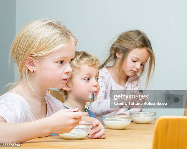 siblings at breakfast - boy pajamas cereal stock pictures, royalty-free photos & images