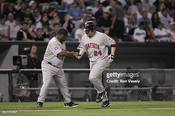Matthew LeCroy of the Minnesota Twins is greeted by third base coach Al Newman during the game against the Chicago White Sox at U.S. Cellular Field...