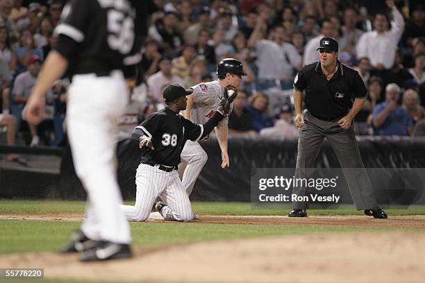 Pablo Ozuna of the Chicago White Sox fields and Lew Ford of the Minnesota Twins stands on-base as umpire Tony Randazzo looks on during the game...