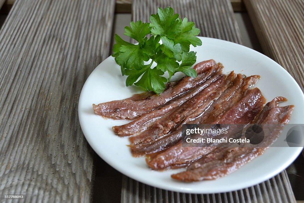 Anchovy fillets on a white plate