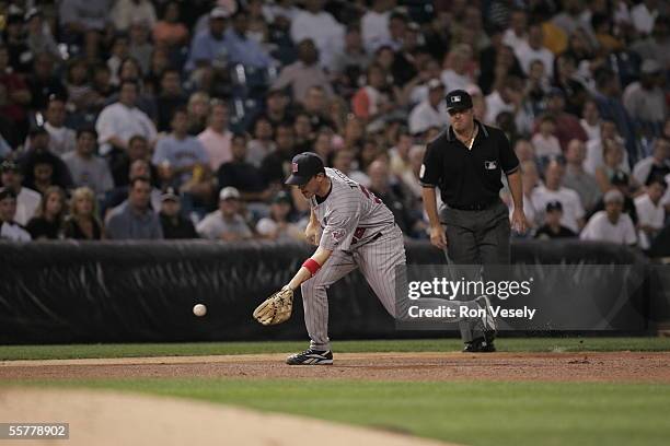 Terry Tiffee of the Minnesota Twins fields as umpire Tony Randazzo looks on during the game against the Chicago White Sox at U.S. Cellular Field on...