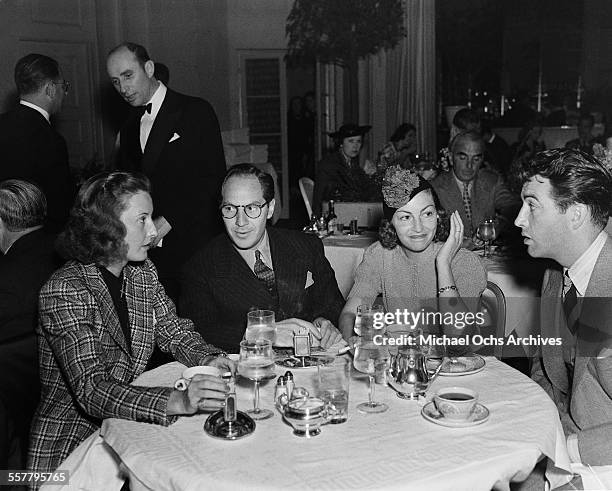 Actress Barbara Stanwyck and her husband actor Robert Taylor have dinner with friends in Los Angeles, California.