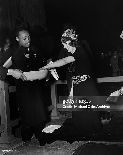 Actress Eleanor Powell cleans her hands after her hands were added to cement in front of Grauman's Chinese Theatre in Los Angeles, California.
